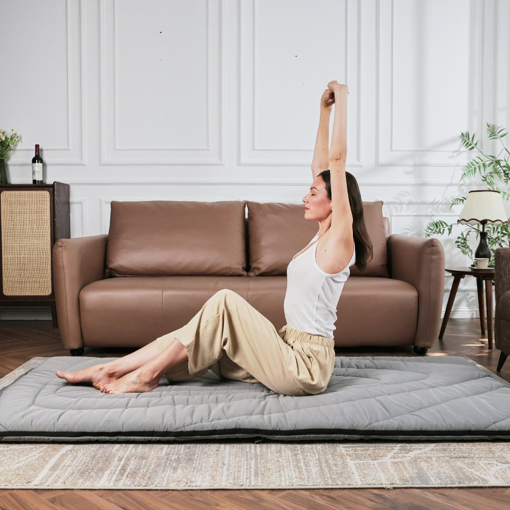 A woman sat meditating on a blanket