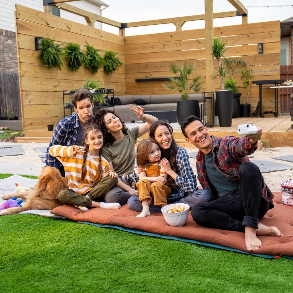 family and friends taking photo on a camping mattress