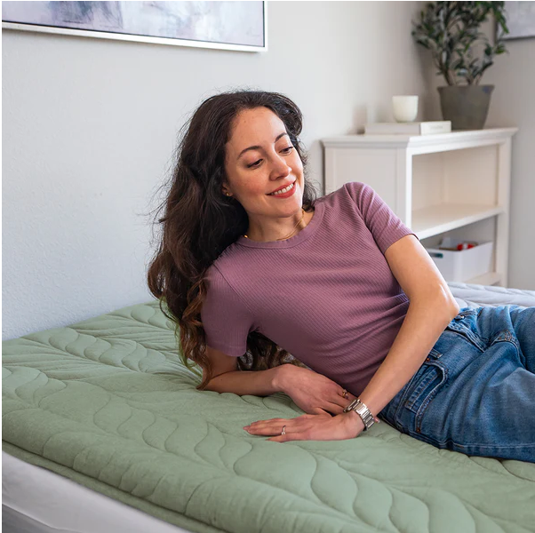 A woman is lying comfortably on a sleeping pad